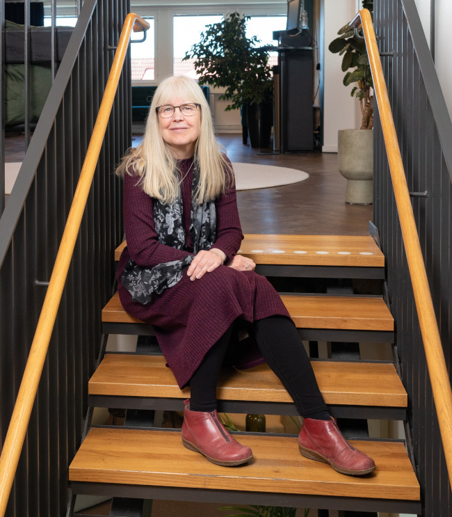 Eva-Lena på Ordkanalen sitter i en trappa.