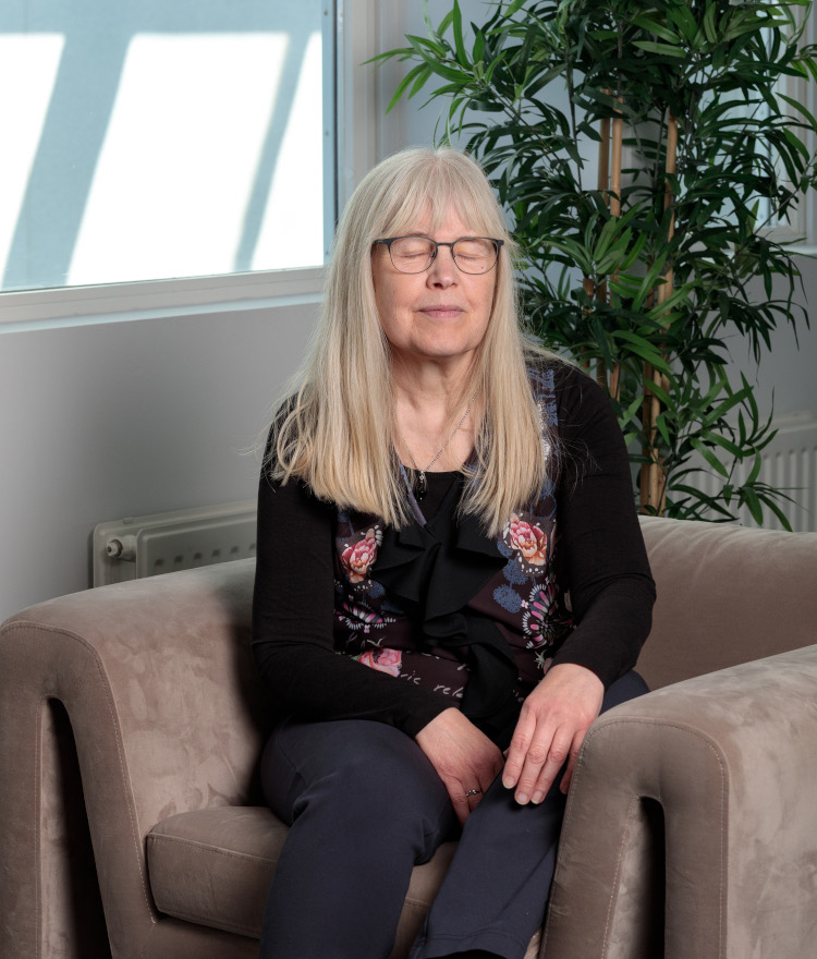 Eva-Lena sitter i en fåtölj och blundar.